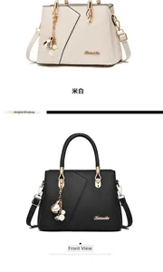 Front view of cream and black pebble leather handbags with gold hardware and charms