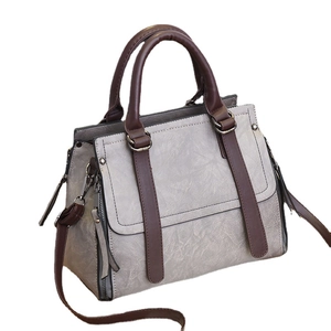 Fashionable taupe PU leather handbag with contrasting brown straps and metal ring decor
