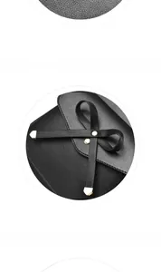 Détail d'un sac à main en cuir noir avec un nœud décoratif et une texture grainée