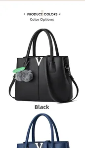 Detail einer schwarzen Handtasche mit Litschi-Maserung, V-Metall-Deko und Plüsch-Anhänger