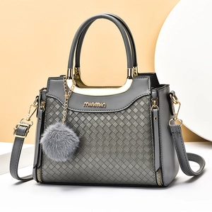 Sac bandoulière gris grande capacité avec motif matelassé et pompon sur présentoir