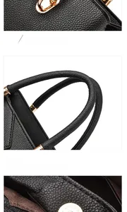 Close-up of black lychee grain leather handbag with gold metal lock and reinforced handle