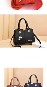 Detail of lychee textured leather handbags with metal hardware and stylish charms