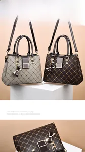 Detail view of stylish tote bag featuring classic prints, metal buckles, and bow charms