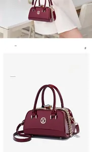 Macro view of burgundy patent leather bag with gold W logo and adjustable strap