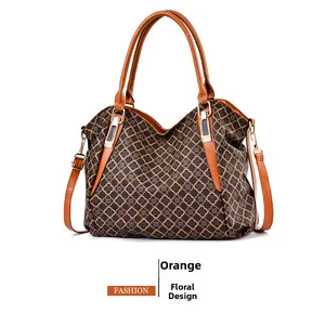 Dettaglio del motivo floreale vintage sulla borsa in morbida pelle con manici arancio