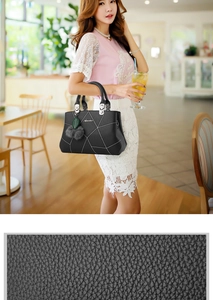 Detail of black pebbled leather texture and geometric embroidery on a stylish tote bag