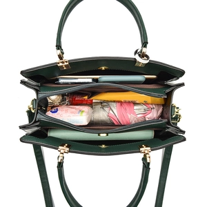 Dark green handbag with multiple compartments showing large storage capacity for daily items