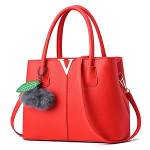 Rote Handtasche aus Leder mit Litschimaserung, goldenem V-Logo und grauem Plüsch-Anhänger