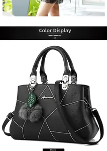 Detail of black lychee grain handbag with geometric stitching and plush ball charm