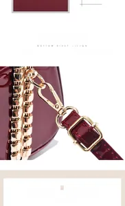 Macro detail of wine red glossy bag with luxury gold detachable metal clasp