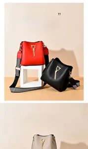 Three leather bucket bags in red, black and beige with cat-ear buckles and tassel detail