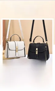 Detail of lychee pattern leather bags in black and white with golden metal hardware