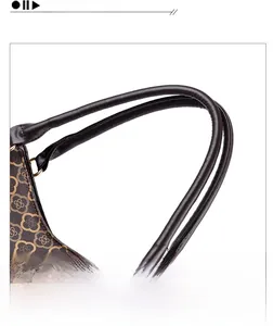 Dettaglio dei manici in pelle e del motivo monogramma floreale sulla borsa tote
