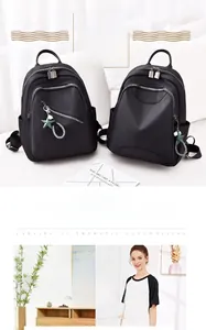 Détail d'un sac à dos noir avec fermetures éclair argentées et pendentifs en strass