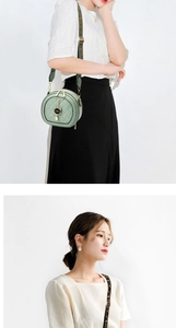 Detail of light green round quilted crossbody bag with wide strap and cat charm decor