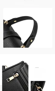 Detail of black lychee grain leather handbag featuring polished gold metal hardware accents