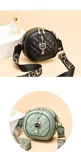Detail of rhombic quilted round crossbody bags with cat charms and wide straps