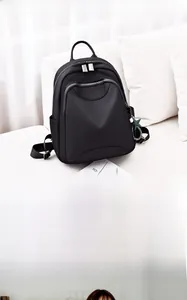 Détail d'un sac à dos multifonctionnel noir stylé avec pendentif étoile et zips argentés