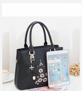 Detaillierter Größenvergleich der bestickten Handtasche mit Tablet und Telefon