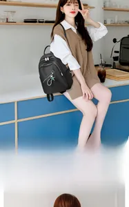 Détail du sac à dos en nylon noir avec fermetures argentées et charm étoile verte