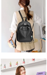 Détail du sac à dos en similicuir noir avec pendentif étoile et fermeture éclair