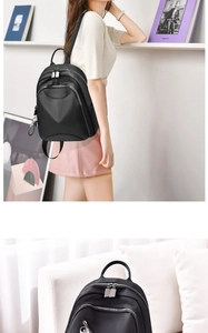 Détail d'un sac à dos noir minimaliste avec fermeture éclair argentée et vue portée par mannequin