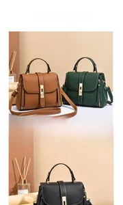 Detail of lychee pattern leather handbag with metallic lock and adjustable shoulder strap