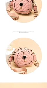 Detail of pink round crossbody bag with quilted pattern, cat charm and wide woven strap