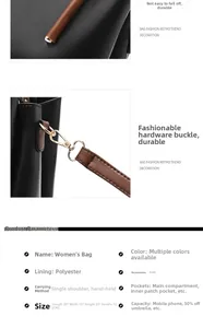 Detail view of large capacity black leather handbag with brown handles and gold hardware