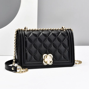 Classic black quilted leather chain bag for women with gold clover buckle in studio setting