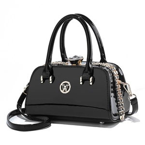 Glossy black patent leather mini handbag with gold hardware and sparkling crystal clasp