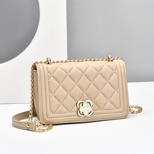 Quilted leather chain bag in beige featuring a gold clover lock and crossbody strap