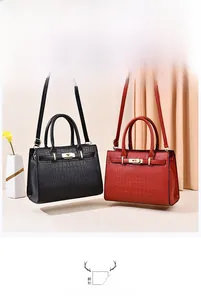 Détail de sacs à main de luxe à motif crocodile noir et rouge avec fermoir doré rotatif