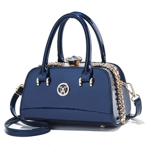 Glossy navy blue patent leather handbag with gold W logo and large rhinestone charm