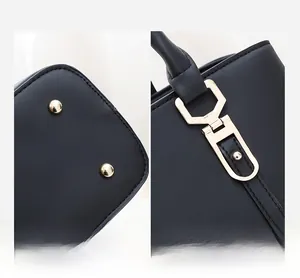 Details goldener Metallbeschläge und Schutzfüße an einer schwarzen Lederhandtasche
