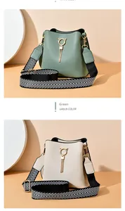Close-up of cat-shaped metal ring and fringe tassels on a textured PU bucket bag