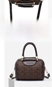 Dettaglio macro della cerniera e della pelle monogrammata su una borsa Boston