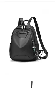 Détail du sac à dos en nylon noir imperméable avec fermetures éclair en métal et décoration de gland