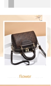 Dettaglio della borsa Boston marrone con monogramma e doppie cerniere dorate