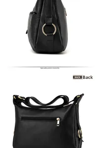 Dettaglio macro della borsa in pelle nera con anelli dorati e tasca con zip sul retro