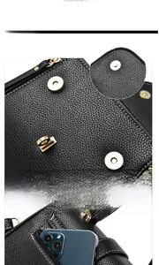 Detail of black lychee leather bag with gold magnetic clasp and smartphone storage