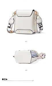 Detail of white leather bag with golden rivets, pearl chain, and wide shoulder strap
