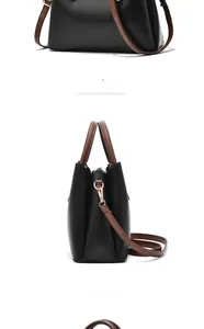 Close-up of black leather handbag featuring brown straps and gold metal hardware