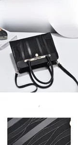 Close-up of black handbag with wave embossing texture and gold metal buckle detail
