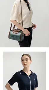 Detail view of small green crocodile texture Boston bag with brown shoulder strap