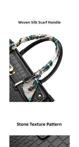 Detail of black crocodile texture handbag with gold clasp and silk scarf handle wrap