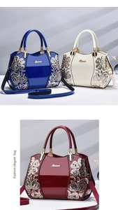 Detail of glossy patent leather handbags with sequins flower embroidery and metal logo