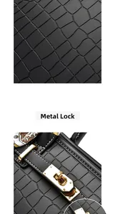 Detail of the golden metallic twist lock and black crocodile embossed leather on the bag