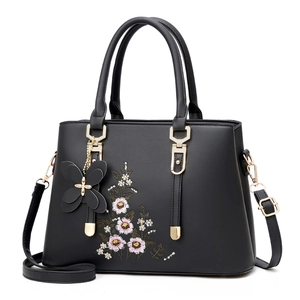 Schwarze Damen-Handtasche mit Blumenstickerei und Schmetterlingsanhänger für Sommer 2025